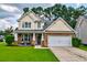 Charming two-story home featuring a manicured lawn, stone accents, and an attached two-car garage at 314 Freeland Way, Moncks Corner, SC 29461