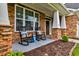 Inviting front porch with stone detailing, white columns, and comfortable rocking chairs at 314 Freeland Way, Moncks Corner, SC 29461