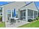 Back patio boasts outdoor dining, adjacent to a cozy screened porch with potted plants at 344 Seaside Trl, Summerville, SC 29486