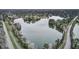 Scenic aerial view of a tranquil lake surrounded by lush trees and a quiet road at 351 Gnarly Oak Ln, Summerville, SC 29485