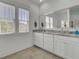 Bright bathroom with a large mirror, dual sinks, marble countertops, and wood-look tile flooring at 351 Gnarly Oak Ln, Summerville, SC 29485