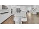 Bright kitchen boasts white cabinets, stainless appliances, quartz counters, and an island with seating at 351 Gnarly Oak Ln, Summerville, SC 29485
