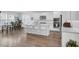 Open kitchen with white cabinetry, stainless appliances, an island with seating, and hardwood floors at 351 Gnarly Oak Ln, Summerville, SC 29485
