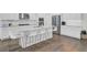 Bright kitchen features white cabinets, stainless appliances, quartz counters, and a spacious island with bar seating at 351 Gnarly Oak Ln, Summerville, SC 29485