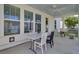 The covered porch has white ceiling, fan, table and chairs for outdoor seating at 351 Gnarly Oak Ln, Summerville, SC 29485