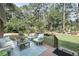 Charming outdoor deck featuring a conversation set and a picturesque landscaped backyard at 3555 Colonel Vanderhorst Cir, Mount Pleasant, SC 29466