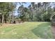 Expansive backyard featuring a well-manicured lawn, mature trees, and a cozy fire pit area perfect for entertaining at 3555 Colonel Vanderhorst Cir, Mount Pleasant, SC 29466