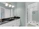 The spacious bathroom has a walk-in shower and a black granite vanity with ample lighting and fixtures at 3555 Colonel Vanderhorst Cir, Mount Pleasant, SC 29466