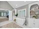 A luxurious soaking tub sits beneath a window with built-in shelving in the bathroom at 3555 Colonel Vanderhorst Cir, Mount Pleasant, SC 29466
