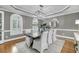 Elegant dining room featuring a modern chandelier, hardwood floors, and a large wood table with white chairs at 3555 Colonel Vanderhorst Cir, Mount Pleasant, SC 29466