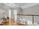 Upstairs hallway featuring hardwood floors, white railings, and contemporary lighting at 3555 Colonel Vanderhorst Cir, Mount Pleasant, SC 29466