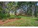 Beautiful backyard featuring lush greenery, towering trees, and pine straw landscaping at 4067 S Rhett Ave, North Charleston, SC 29405
