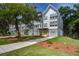 Multi-story gray townhomes feature yellow doors, multi-car garages, and landscaped lawns at 4067 S Rhett Ave, North Charleston, SC 29405
