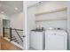 Well-lit laundry room with modern washer, dryer and wood shelving at 4067 S Rhett Ave, North Charleston, SC 29405