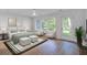 Staged bedroom features an ensuite with hardwood floors, ceiling fan, and bright backyard views at 4067 S Rhett Ave, North Charleston, SC 29405