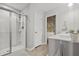 Bright bathroom featuring a glass door shower, and a peek into a floral wallpapered water closet at 470 Sanctuary Park Dr, Summerville, SC 29486