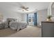 A serene bedroom with a comfortable bed, a ceiling fan, and soft natural light filtering through the windows at 470 Sanctuary Park Dr, Summerville, SC 29486