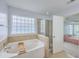 Bright bathroom features a soaking tub, glass enclosed shower, and doorway to the main bedroom at 531 Crossland Dr, Moncks Corner, SC 29461