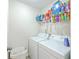 Laundry room with white front loading washer and dryer, wire shelving, and tile flooring at 531 Crossland Dr, Moncks Corner, SC 29461