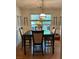This bright dining area features a wooden table, four chairs, a chandelier, and wine racks on the wall at 5423 Buckeye Rd, Hollywood, SC 29449