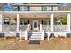 Inviting two-story home featuring a spacious covered front porch with white columns and porch swing at 62 Wexford Way, Walterboro, SC 29488