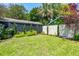 Lush backyard with a well-manicured lawn, privacy fence, and ornamental trees and shrubs at 66 Darlington Ave, Charleston, SC 29403