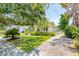 Beautifully landscaped home with mature trees, lush shrubs, and a welcoming front yard at 66 Darlington Ave, Charleston, SC 29403