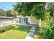 Charming garage with olive doors, lovely landscaping, and stone walkway leading to the main house at 66 Darlington Ave, Charleston, SC 29403