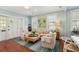 Cozy living room featuring hardwood floors, comfortable seating, and ample natural light from the windows at 66 Darlington Ave, Charleston, SC 29403