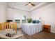 Bedroom features a crib, rocking chair, and a cozy bed near a window at 6972 Pumpkinseed Dr, Johns Island, SC 29455