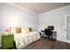 Bright bedroom featuring a colorful quilt, wood floors, and a functional desk area at 6972 Pumpkinseed Dr, Johns Island, SC 29455