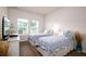 Bright bedroom with two twin beds, hardwood floors, and a view of the neighborhood at 6972 Pumpkinseed Dr, Johns Island, SC 29455