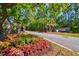 Landscaped community entrance of Saint Johns Lake with brick structures and fresh colorful flowers at 6972 Pumpkinseed Dr, Johns Island, SC 29455