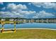 A wooden kayak rack on the grassy bank of a calm, reflective pond at 6972 Pumpkinseed Dr, Johns Island, SC 29455