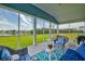 Comfortable screened porch with wicker furniture overlooking serene lake and lush lawn at 6972 Pumpkinseed Dr, Johns Island, SC 29455