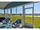 Relaxing screened porch with wicker furniture and a beautiful view of the serene pond at 6972 Pumpkinseed Dr, Johns Island, SC 29455