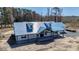 Aerial view of home exterior with blue roof, white siding, black trim, covered porch at 709 Oakridge View Trl, Ridgeville, SC 29472