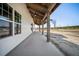 Long covered porch with exposed-beam ceiling, and concrete floor at 709 Oakridge View Trl, Ridgeville, SC 29472