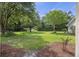 Lush backyard with mature trees and green grass, offering plenty of space for outdoor activities at 7879 Gull Bay Dr, Awendaw, SC 29429