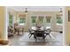 Sunlit dining room featuring a ceiling fan, a table with seating for four, and views of the backyard at 7879 Gull Bay Dr, Awendaw, SC 29429