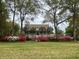 Large home with trees and colorful azaleas framing the front yard at 7879 Gull Bay Dr, Awendaw, SC 29429
