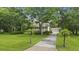 Beautiful home surrounded by lush greenery, featuring a long driveway leading to a three-car garage at 7879 Gull Bay Dr, Awendaw, SC 29429