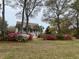 Charming two-story home with white columns, dormer windows, and vibrant azaleas in the front yard at 7879 Gull Bay Dr, Awendaw, SC 29429