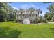 Charming two-story home with a manicured lawn and a grand staircase leading to a welcoming front porch at 7879 Gull Bay Dr, Awendaw, SC 29429
