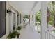 Inviting front porch with white columns, rocking chairs, and lush greenery, perfect for relaxing outdoors at 7879 Gull Bay Dr, Awendaw, SC 29429