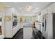 Modern kitchen with stainless steel appliances, black tile flooring, and white cabinets at 7879 Gull Bay Dr, Awendaw, SC 29429
