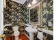 Stylish powder room featuring unique floral wallpaper, pedestal sink, and elegant mirror at 7879 Gull Bay Dr, Awendaw, SC 29429