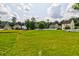 Lush green backyard showcasing a serene view of neighboring homes and mature trees at 8938 Planters Row Ln, Summerville, SC 29485