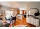 Bright dining area with a view to the kitchen, modern furnishings, and wood floors at 8938 Planters Row Ln, Summerville, SC 29485