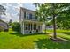 Two-story home with a well-maintained lawn, a welcoming front porch, and classic curb appeal at 8938 Planters Row Ln, Summerville, SC 29485